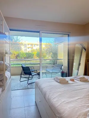 a bedroom with a large bed and a balcony at Le Ciel de Fabron Piscine et Tennis in Nice