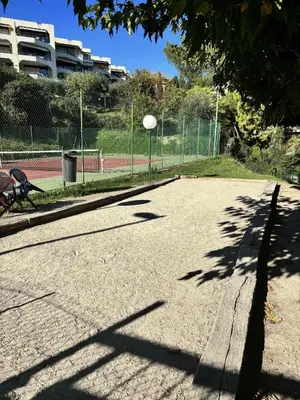 an empty tennis court with a bench and a tennis court at Le Ciel de Fabron Piscine et Tennis in Nice