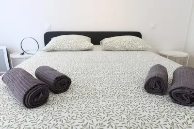 a bedroom with a bed and a table with a chair at Nice Time - Chic Apartment with sunny terrace, Nice Port in Nice