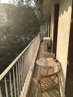 a porch with two chairs and a table on a balcony at 3 pièces 10 min de la mer et du tram in Nice