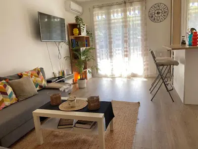 a living room with a couch and a table at 3 pièces 10 min de la mer et du tram in Nice