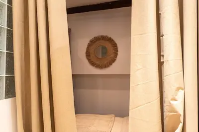 a room with a mirror and a curtain and a mirror at L'Adresse du Choeur - Vieux Nice in Nice