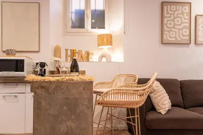 a kitchen and a living room with a couch at L'Adresse du Choeur - Vieux Nice in Nice