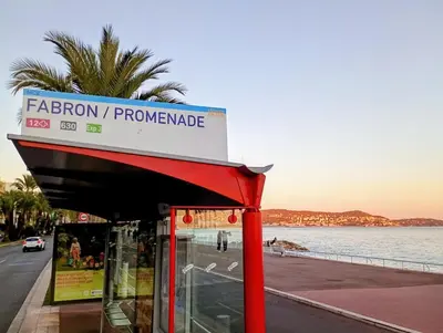 a bus stop with a sign on it next to the water at Artemare, il fascino del classico con ogni comfort in Nice