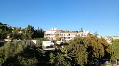 a large white building in the middle of trees at Artemare, il fascino del classico con ogni comfort in Nice