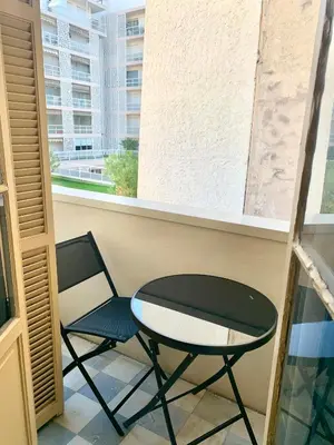 a table and a chair in a room with a window at Studio Carré Or avec balcon in Nice