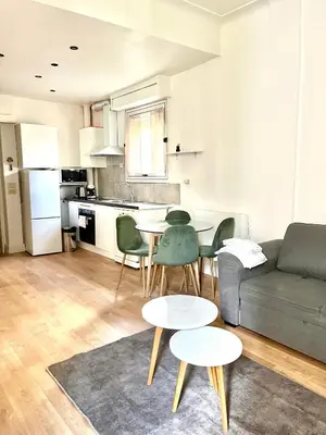 a living room with a couch and a table and chairs at Studio Carré Or avec balcon in Nice