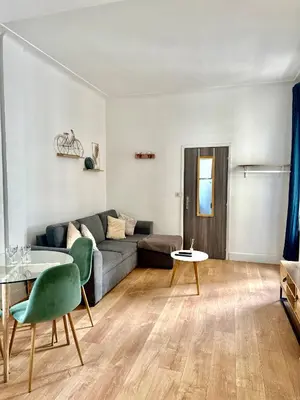 a living room with a couch and a table at Studio Carré Or avec balcon in Nice