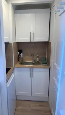 a small kitchen with white cabinets and a sink at Studio Nice cosy et plein centre in Nice