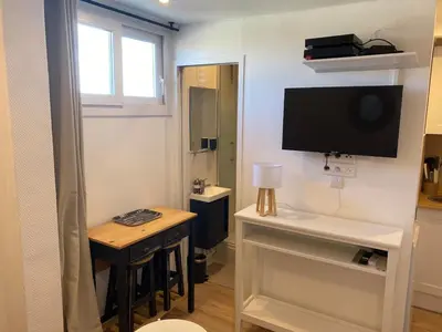 a small room with a television and a desk with a table at Studio Nice cosy et plein centre in Nice