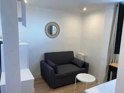 a living room with a black chair and a mirror at Studio Nice cosy et plein centre in Nice