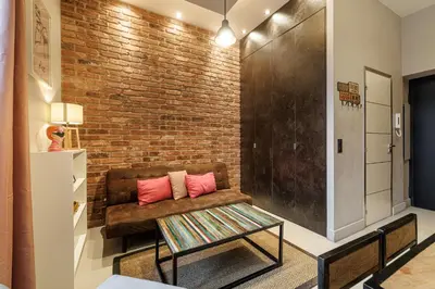 a living room with a couch and a brick wall at Charming 1 Bdr Downtown in Nice