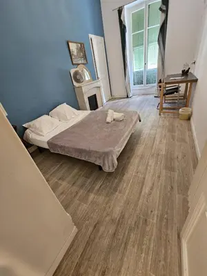 a bedroom with a bed and a wooden floor at superbe chambre plein centre Nice climatisé direct aéroport via tram in Nice