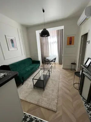a living room with a green couch and a table at Appartement au centre calme in Nice