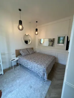 a bedroom with a bed and a table and mirrors at Appartement au centre calme in Nice