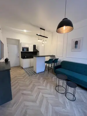 a living room with a couch and a table and chairs at Appartement au centre calme in Nice