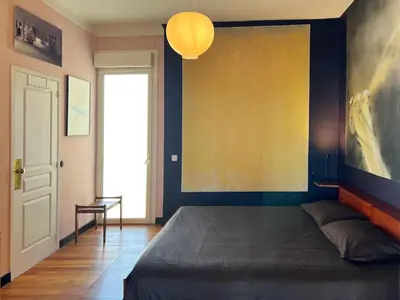 a bed in a room with a painting on the wall at Design et Art in Nice