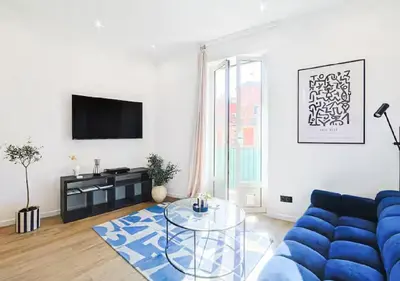 a living room with a blue couch and a glass table at Splendide Appartement Neuf au Port de Nice in Nice