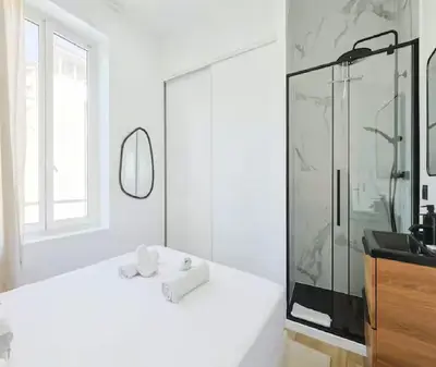 a white bathroom with a shower and a sink at Splendide Appartement Neuf au Port de Nice in Nice