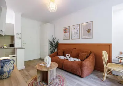 a living room with a brown couch and a table at Le Bijou de Grimaldi Emplacement de Rêve Plage in Nice