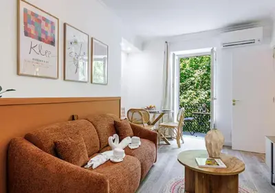 a living room with a brown couch and a table at Le Bijou de Grimaldi Emplacement de Rêve Plage in Nice