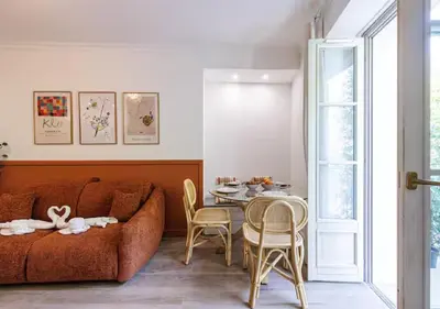 a living room with a couch and a table with chairs at Le Bijou de Grimaldi Emplacement de Rêve Plage in Nice