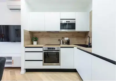 a kitchen with white cabinets and a stove at Carre dOr Design Confort and Centralité in Nice