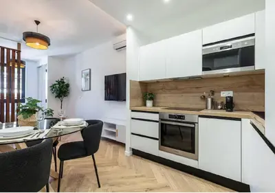a kitchen with white cabinets and a table with chairs at Carre dOr Design Confort and Centralité in Nice