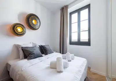 a white bed in a room with a window at Carre dOr Design Confort and Centralité in Nice