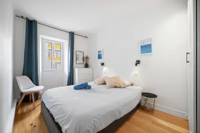a bedroom with a bed and a chair at Les Palmiers, quiet and air-conditioned in Nice