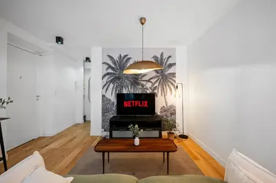 a living room with a tv and a coffee table at Les Palmiers, quiet and air-conditioned in Nice