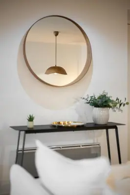 a mirror on a wall above a table with a chair at Les Palmiers, quiet and air-conditioned in Nice