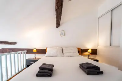 a bedroom with a white bed with towels on it at Le Riviera France in Nice