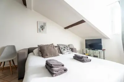 a bedroom with a white bed with towels on it at Le Riviera France in Nice