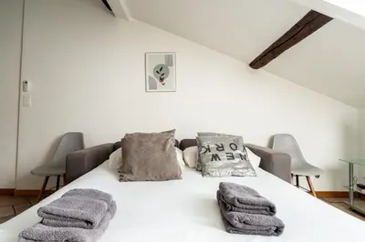a white bed with pillows and towels on it at Le Riviera France in Nice