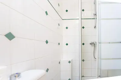 a white bathroom with a shower and a sink at Le Riviera France in Nice