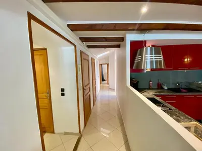 a hallway leading to a kitchen with red cabinets at T4 Nice Centre - Close to shops, Wi-Fi, AC in Nice