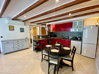 a kitchen with red cabinets and a table and chairs at T4 Nice Centre - Close to shops, Wi-Fi, AC in Nice
