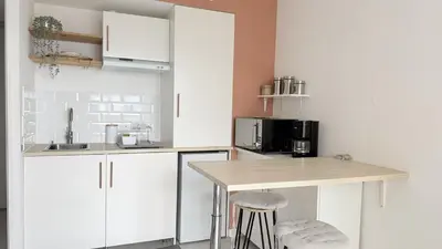 a kitchen with white cabinets and a wooden counter top at Studio Vue Mer Nice in Nice