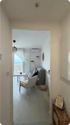 a white living room with a chair and a desk at Studio Vue Mer Nice in Nice