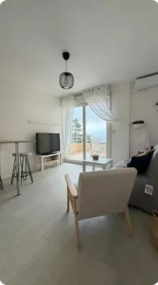 a living room with a couch and a table at Studio Vue Mer Nice in Nice