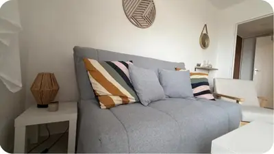 a couch with pillows on it in a living room at Studio Vue Mer Nice in Nice