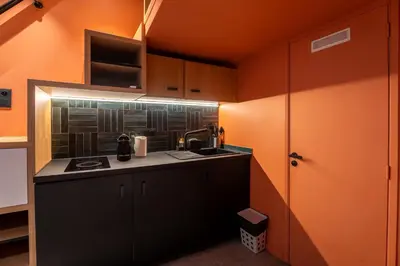 a small kitchen with orange walls and a sink at La Casa Nissa in Nice