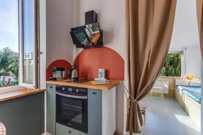 a kitchen with a stove and a sink in a room at STUDIO AZUR AP4487 By Riviera Holiday Homes in Villefranche-sur-Mer