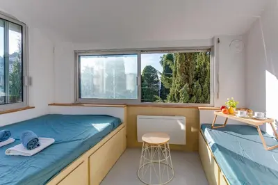 a small room with two beds and a stool at STUDIO AZUR AP4487 By Riviera Holiday Homes in Villefranche-sur-Mer