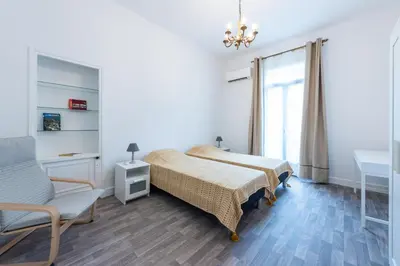 a bedroom with a bed and a chair and a window at Happyfew maison Michelet in Nice