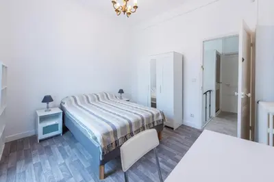 a white bedroom with a bed and a mirror at Happyfew maison Michelet in Nice