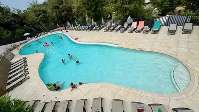 a large swimming pool with people in the water at Cosy mobil-home wifi clim in Cagnes-sur-Mer