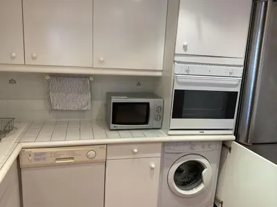 a kitchen with a microwave and a washing machine at Duplex Apartment Old Town & Beach in Villefranche-sur-Mer