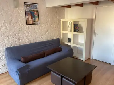 a living room with a blue couch and a table at Duplex Apartment Old Town & Beach in Villefranche-sur-Mer